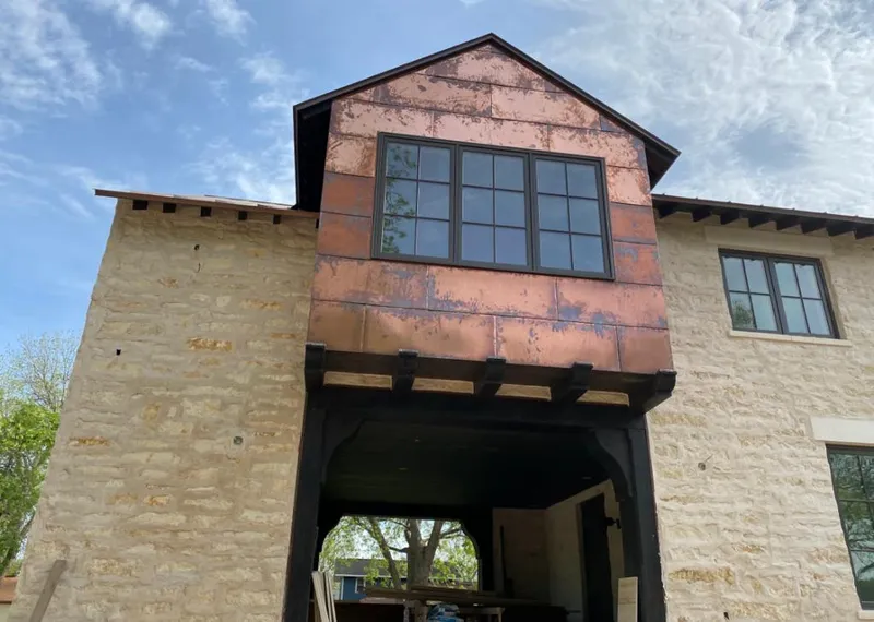Copper metal panel facade on a stone building for Roof Repair in Paloma Creek South